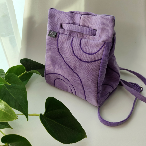 Front view of a KOLLIB purple upcycled denim bohemian style backpack.