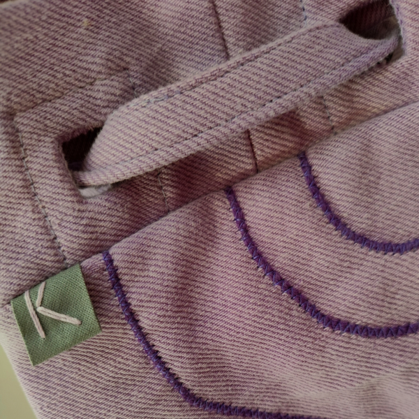 Detail view of a KOLLIB purple upcycled denim bohemian style backpack.